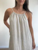 Vestido largo de lino color crudo, con escote halter fruncido y abertura lateral en la falda.