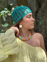 Collar corto con cuentas de resina y cerámica de colores naranja, rosa, verde, celeste y beige. Tiene tiento sintético con cierre ajustable.