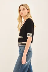 Cardigan negro de viscosa con lurex, manga corta y cierre con botones a presión.