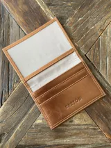 Tarjetero de cuero vacuno color celeste con ranuras para tarjetas y bolsillo exterior.