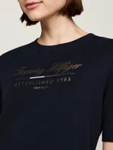 Vestido Tommy Hilfiger azul marino de corte recto y largo a la rodilla, con mangas cortas y cuello redondo. Presenta el logo de la marca bordado en el pecho.