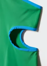 Minivestido verde con terminaciones en contraste color celeste, de un solo hombro y con abertura circular en la cintura.