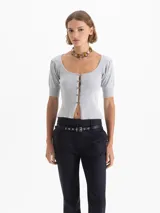 Top corto gris de punto acanalado, con escote redondo, manga corta abullonada y cierre frontal con tres ganchos decorados con piedras.