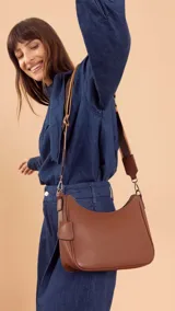 Bandolera morral negra de símil cuero, con cierre trasero y división interna. Incluye correa de galón ajustable.