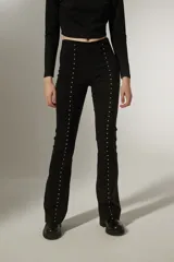 Calza negra de viscosa, corte oxford y tiro alto, con detalle de tachas plateadas en los laterales.