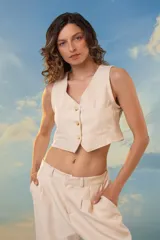 Chaleco corto negro de crepé con lurex y tres botones nacarados. Diseño de sastrería reversionada.