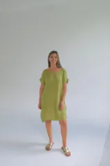 Vestido corto color verde pistacho, de lino italiano, corte suelto, escote redondeado, mangas cortas y botones decorativos en los costados.