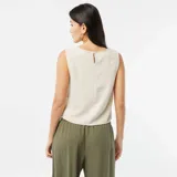 Blusa corta color crema de lino sin mangas y cuello redondo.