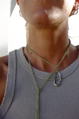 Collar con dije irregular dorado y cordón marrón ajustable.