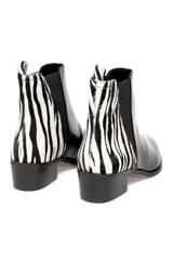Bota corta negra de cuero charol con elástico lateral y detalle de estampado animal print en el talón.