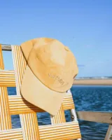 Gorro de pana color mostaza con visera y bordado frontal con la palabra "Yamba".