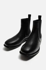 Bota Chelsea de cuero negro, con elásticos laterales, tirador trasero y suela con ligero tacón.