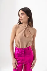 Top negro brillante con escote halter y espalda descubierta.