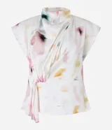 Blusa sin mangas de tela satinada color blanco, con cuello drapeado, lazo lateral y estampado de manchas en tonos rosados, amarillos y verdes.