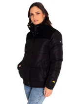 Campera puffer negra con cuello alto, cierre frontal con botones a presión, bolsillos laterales, puños y ruedo acanalados. Tiene un parche con el logo de Caterpillar en la manga izquierda y forro estampado con el logo de la marca.