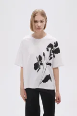 Remera blanca de corte holgado con estampado de flores negras.