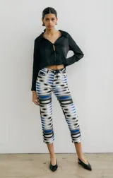 Pantalón jean recto con estampado abstracto en tonos azul, gris y blanco.