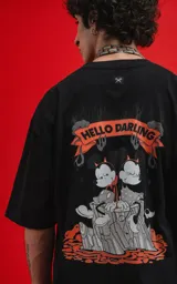 Remera negra de manga corta con cuello redondo y corte oversize. Estampado en la espalda con diseño de Mickey y Minnie Mouse disfrazados de diablos, con la frase "Hello Darling" en una pancarta.