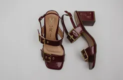 Sandalias negras acharoladas con doble hebilla y taco cuadrado.