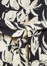 Mono largo de viscosa color crema con estampado floral fucsia, cuello camisero, manga corta, dos bolsillos laterales, trabillas y cinturón con lazo.