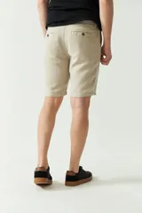 Bermuda de lino y algodón color beige, con bolsillos laterales y traseros, cierre con botón y presillas para cinturón.