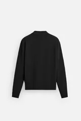 Camisa de punto color negro, corte relaxed fit, con cuello solapa, manga larga y cierre frontal con botones.