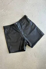 Short negro de cuero napa, tiro alto, con bolsillos delanteros y traseros.