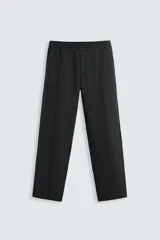 Pantalón wide fit confeccionado en tejido de algodón con interior en rizo, color negro. Cintura elástica ajustable con cordón interior, bolsillos frontales y detalle de bolsillo trasero de vivo. Perneras con costura frontal y efecto lavado.