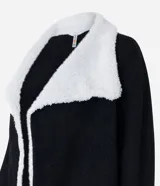 Cardigan alargado color blanco, con cuello virada, forro de pelos y confeccionado en punto pesado. No tiene cierre.