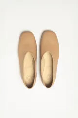 Chatas color beige de cuero vacuno, con talón suave y capellada metalizada.