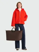 Bolso de viaje Longchamp modelo Le Pliage Green XL, color marrón chocolate, con asas cortas y cierre superior con cremallera y botón a presión.