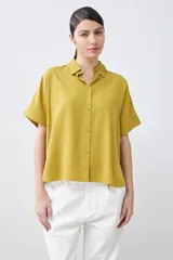 Camisa color pistacho de lyocell con cuello clásico, cierre frontal con botones y mangas cortas.