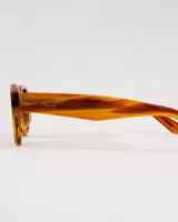 Anteojos de sol con montura gruesa de acetato premium color carey (marrón jaspeado). Tienen forma ovalada y lentes de color marrón oscuro polarizados con filtro UV 400.