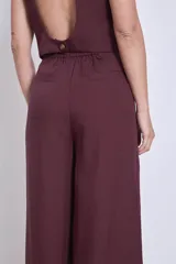 Pantalón ancho de tiro alto color vino, con pliegues frontales y bolsillos laterales.