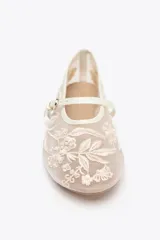 Zapato plano tipo bailarina color beige, con cuerpo de mesh bordado con flores y perlas, tira delantera con hebilla y punta redonda.