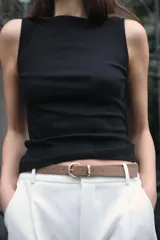 Camiseta sin mangas a rayas horizontales blancas y negras, con cuello barco y corte ajustado.