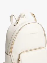 Mochila Tommy Hilfiger color blanco con detalles en dorado. Tiene un compartimento principal con cierre de cremallera, un bolsillo frontal con cierre, asa superior y correas ajustables.