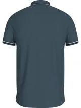 Chomba Tommy Hilfiger azul petróleo de corte slim fit, confeccionada en algodón elástico. Presenta cuello y puños acanalados con doble línea blanca, cartera de tres botones y logo bordado en el pecho.