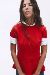 Remera roja entallada de punto interlock pesado, con cuello redondo, mangas cortas, pinzas moldeadoras en la cintura y bajo acampanado.