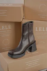 Bota de cuero color marrón con caña media y punta cuadrada.