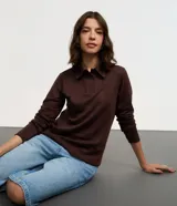 Blusa polo celeste de mangas largas confeccionada en tejido interlock compuesto por algodón BCI.