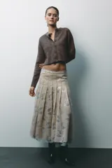 Chaqueta de punto color marrón con aberturas laterales y cierre frontal con botones.