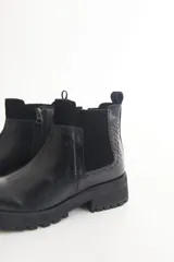 Botas cortas marrones con textura símil cuero de reptil, elástico lateral, cierre lateral con cremallera y suela track.