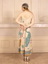 Vestido midi de tirantes finos con estampado de tigres, palmeras y limones. Tiene detalles de lurex y un borde con diseño geométrico. Incluye un cintillo para el pelo a juego.