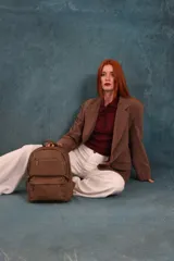 Mochila color marrón de símil cuero con un compartimento principal amplio, bolsillo al frente con cierre, correas ajustables y asa.