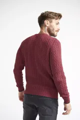 Sweater de punto color burdeos, de corte regular con cuello redondo y mangas largas, con logo metálico.