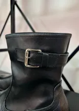 Botas de caña corta con cierre lateral y hebilla decorativa.