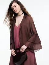 Camisa marrón traslúcida con cuello clásico, cierre frontal con botones y mangas largas con volados.