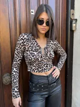 Top corto de mangas largas con estampado de leopardo y escote en V con detalle metálico.