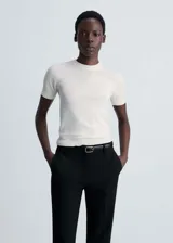 Jersey negro de punto fino, manga corta y cuello redondo.